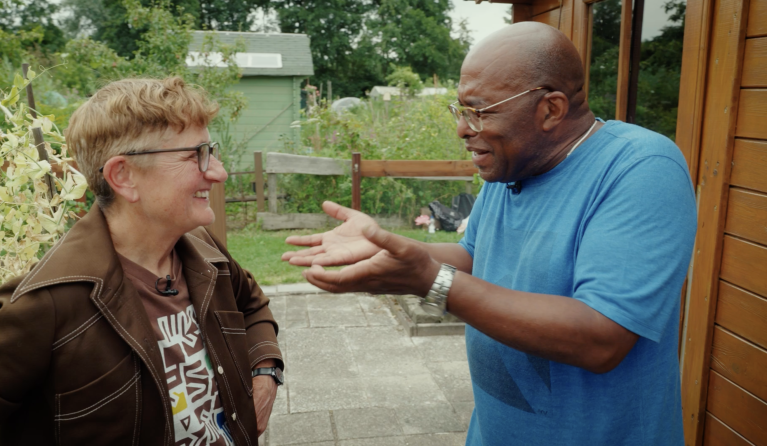 Een man en een vrouw in gesprek in een tuin